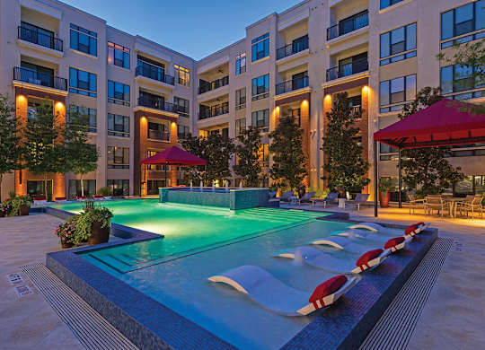 A swimming pool in front of apartment buildings.