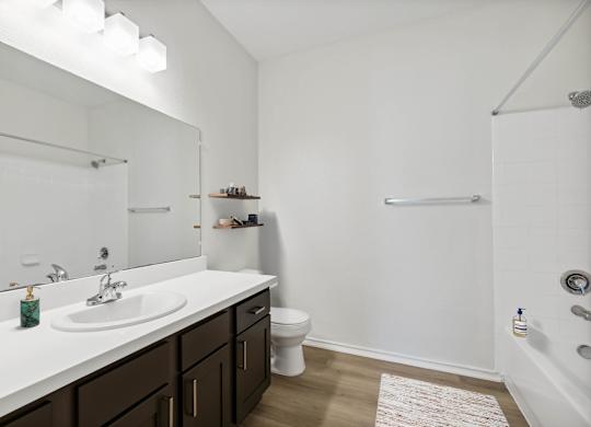 A white bathroom with a sink, toilet, and bathtub.