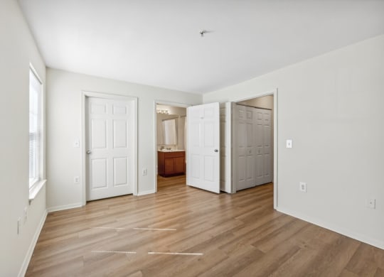 an empty living room with white walls and wood floors