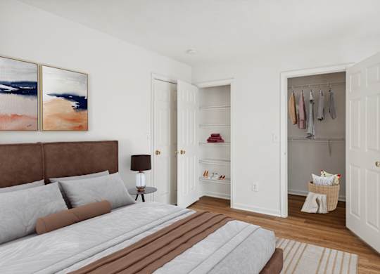 A bedroom with a bed, a nightstand with a lamp, a wardrobe with clothes hanging and a painting on the wall.