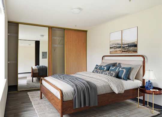 A bedroom with a bed, a nightstand, and a chair.
