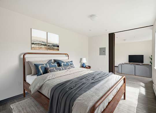 A bedroom with a large bed and a painting on the wall.