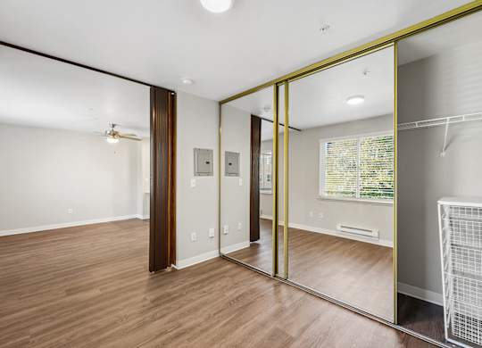 Bedroom with mirror closet at Auburn Court Apartments in Auburn WA