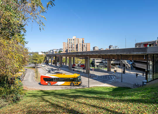 A yellow bus is parked on the side of a road at Belhaven Apartments in Alexandria VA