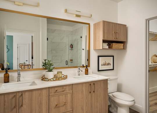 A bathroom with a white counter top and wooden cabinets.