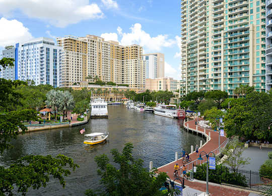A view of a river with boats and buildings in the background.