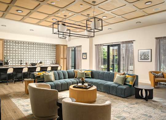 A modern living room with a large green sofa and a wooden coffee table.