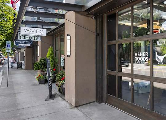The image shows the front of a building with a glass door and a sign that reads