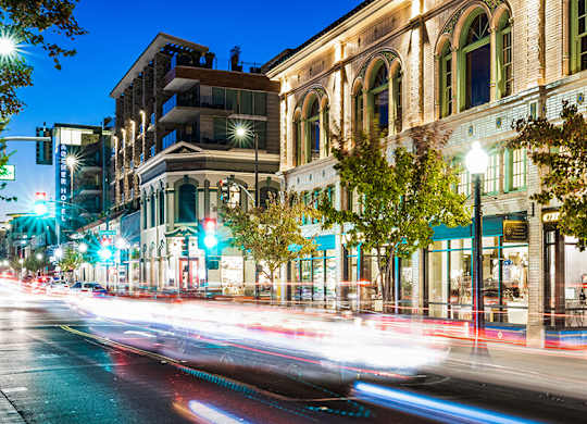A long exposure shot of a city street at night with light trails from moving vehicles