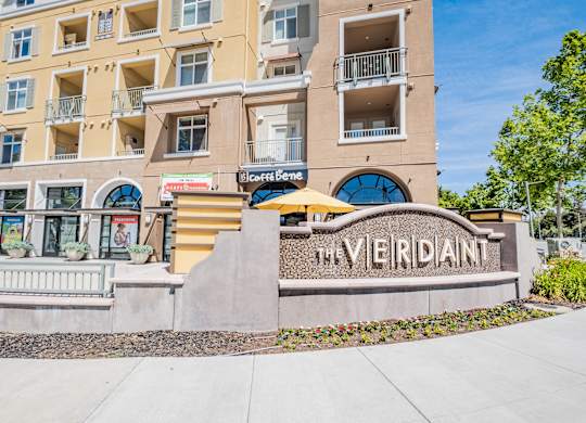 The Verdant is a multi-story apartment building with a sign in front.