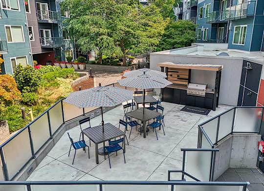 A patio with a table and chairs and an umbrella.