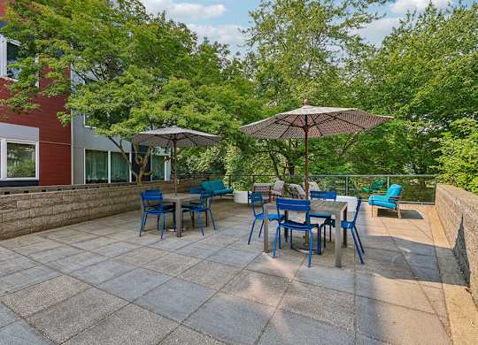 A patio with a table and chairs under umbrellas.