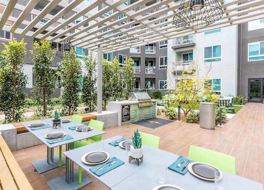 A communal area with tables and chairs in an open courtyard at Avel Apartment Homes in Orange CA
