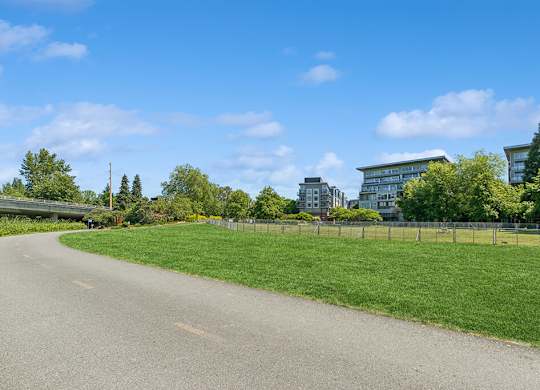 A road with a fence and green grass on the side.