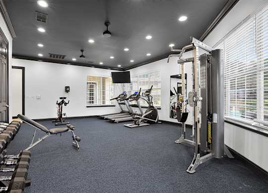 A gym with a variety of equipment including weights and machines.