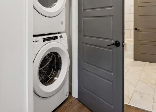 A white dryer is in a small laundry closet.
