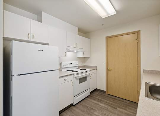 Kitchen with white appliances at Ballinger Court Senior Apartments in Edmonds WA