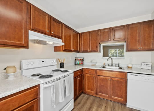 a kitchen with white appliances and wooden cabinets