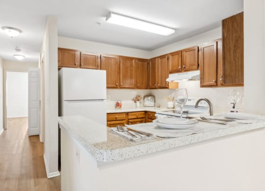 a kitchen with white counter tops and wooden cabinets