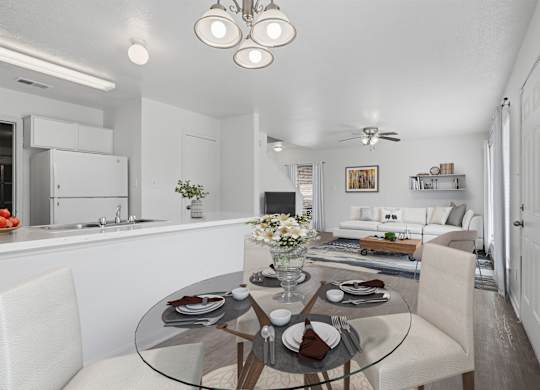 A modern dining room with a glass table and white chairs.