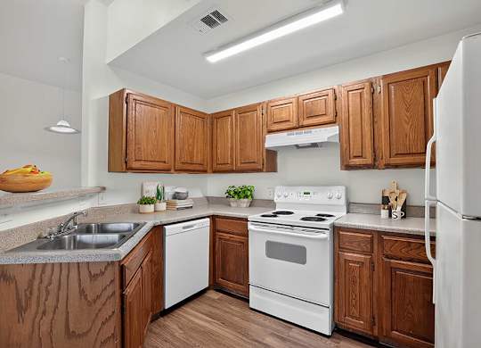 A kitchen with wooden cabinets and white appliances.