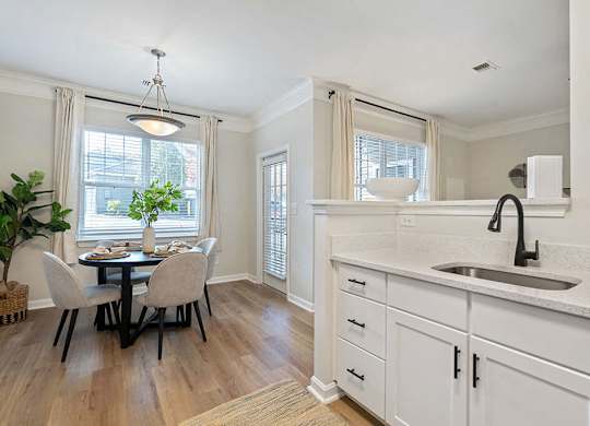 a kitchen with a sink and a table with chairs