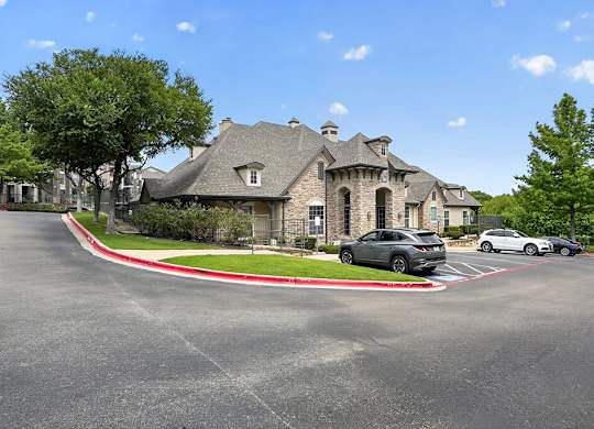 A large house with a grey car parked in front.