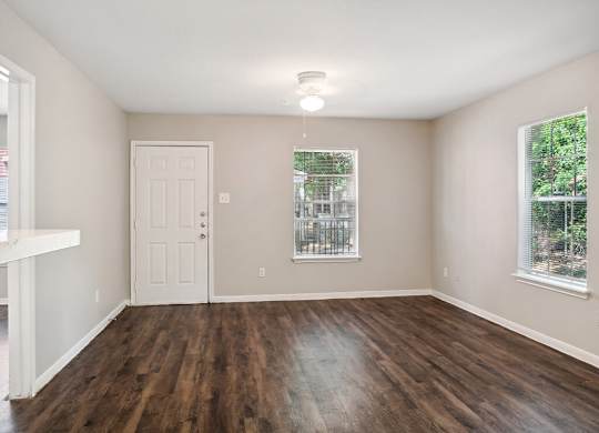 Living room with wood flooring at Park Village Apartments in Conroe TX