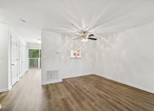 a living room with white walls and a ceiling fan