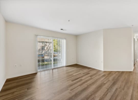 an empty living room with a door to a balcony