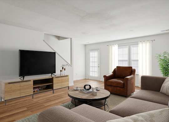 A living room with a brown leather chair and a black television.