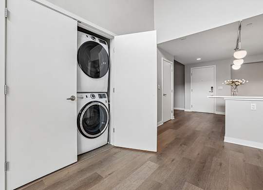 A white laundry room with a washer and dryer in a cabinet.