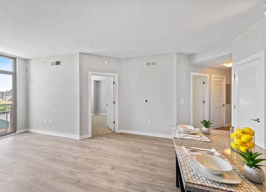 Model living area with wood style flooring at Bradley Braddock Road Station Apartments in Alexandria VA