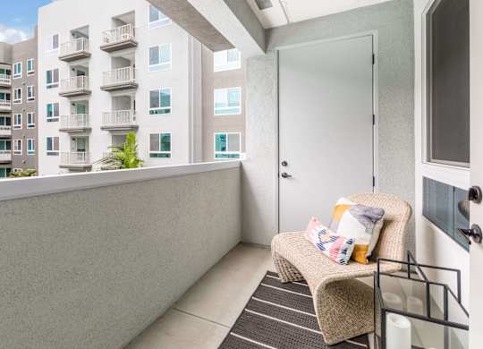 A private balcony with a wicker chair at Avel Apartment Homes in Orange CA
