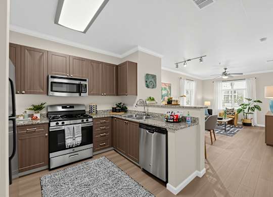 A modern kitchen with brown cabinets and stainless steel appliances.