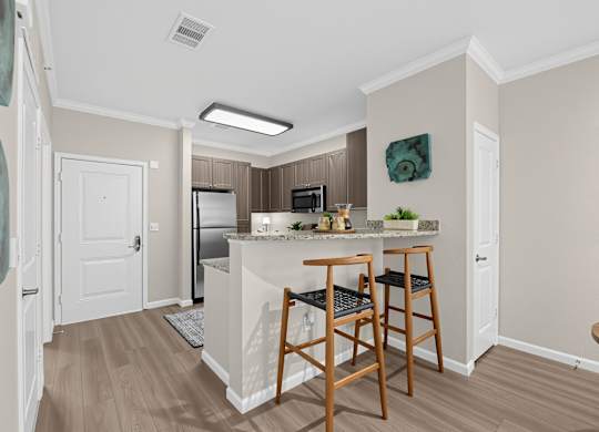 A kitchen with a refrigerator, microwave, and oven.