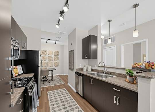 A modern kitchen with dark brown cabinets and a black refrigerator.