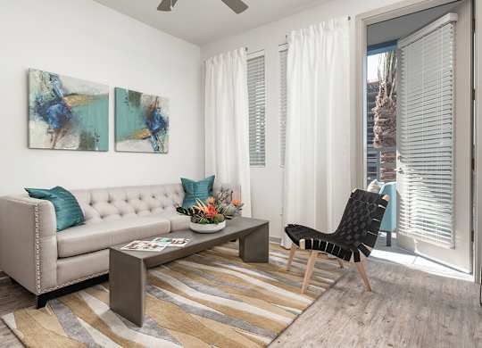 a living room with white walls and a sliding glass door at Norte Town Lake Apartments in Tempe Arizona