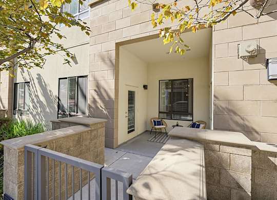 A modern house with a stone wall and a white fence.