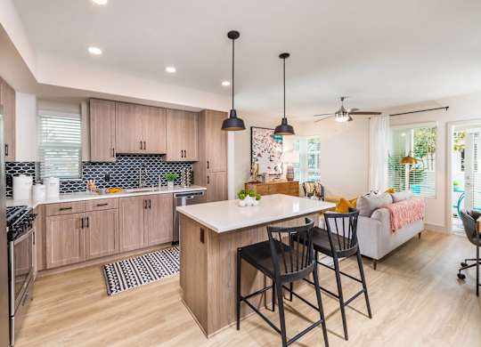 Sepia Design Package Kitchen with island seating and light wood cabinets at The Seaton Apartments in San Diego CA
