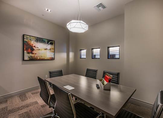 A conference room with a large table and chairs.