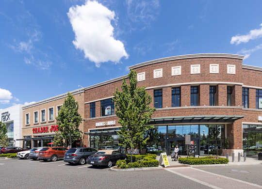 A parking lot with cars and a building with a sign that says