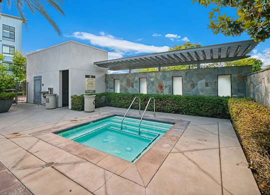 A small pool in a patio with a building in the background.