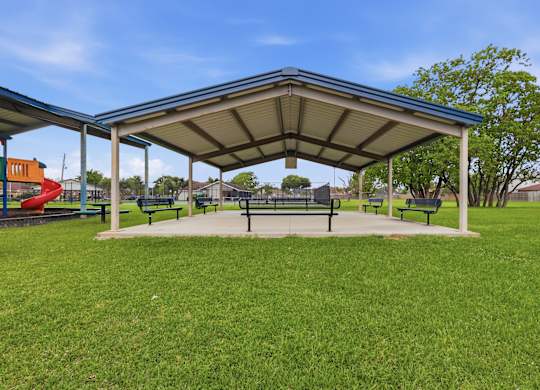 A park with a canopy and benches.