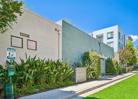 A street view of a building with a green lawn and a sign that says