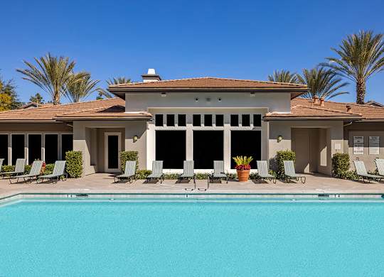 A large house with a pool in front.