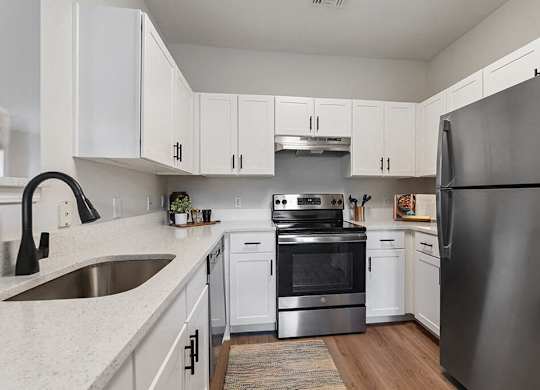 a kitchen with stainless steel appliances and white cabinets