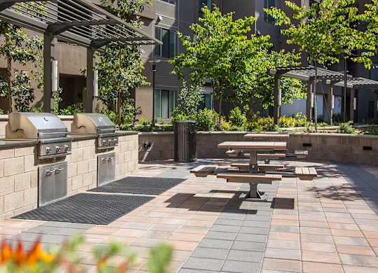 A patio with a table and chairs under a pergola.