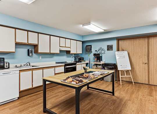 A kitchen with a table in the middle of it.