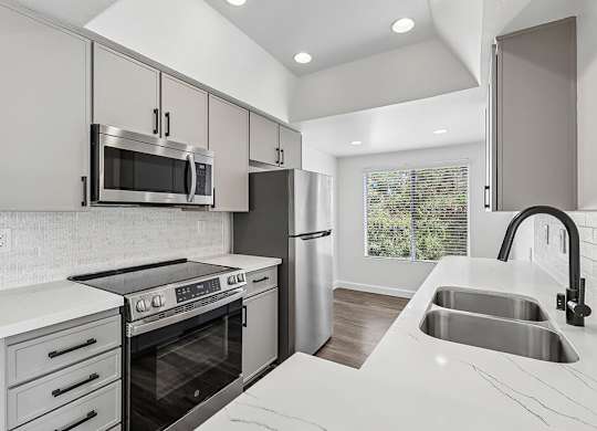 A modern kitchen with a stove, oven, and refrigerator.